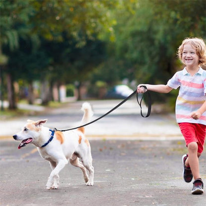 Enfant promenant son chien avec une laisse de chien noire en extérieur